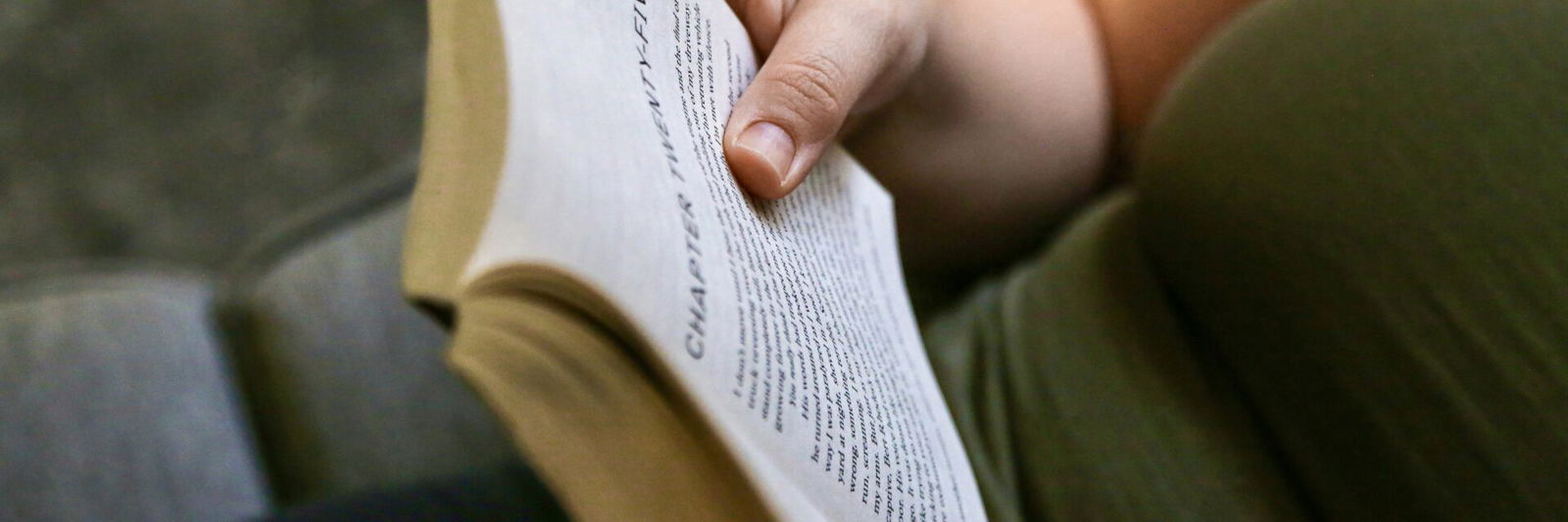 Person reading a book on couch
