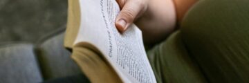 Person reading a book on couch